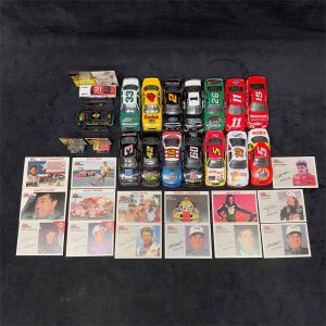 Overhead view of full NASCAR diecast car collection with 18 vehicles and matching trading cards
